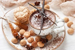Aromatic cocoa drink with cinnamon, anise and sweet cookies on  wooden background