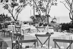 Arrangement de table de dîner de réception de mariage avec les chaises de jardin se pliantes en noir et blanc photographie stock libre de droits Arrangement de table de dîner de réception de mariage avec les chaises de jardin se pliantes en noir et blanc photographie stock libre de droits