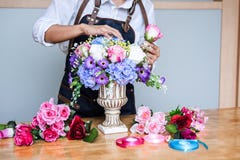 Arreglando las flores artificiales conceden la decoraci?n en casa, el trabajo del florista de la mujer joven que hace la flor art imagen de archivo Arreglando las flores artificiales conceden la decoraci?n en casa, el trabajo del florista de la mujer joven que hace la flor art imagen de archivo