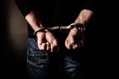Arrested criminal with handcuffs stock photo Arrested criminal with handcuffs stock photo