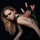 Art beauty girl with lilies behind on a black background. Creati stock photography Art beauty girl with lilies behind on a black background. Creati stock photography