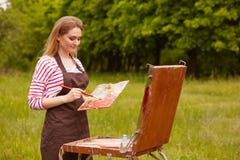 Artista inspirado talentoso que sostiene el equipo profesional en ambas manos, pintando en el aire abierto, encariñado con la nat fotografía de archivo libre de regalías Artista inspirado talentoso que sostiene el equipo profesional en ambas manos, pintando en el aire abierto, encariñado con la nat fotografía de archivo libre de regalías
