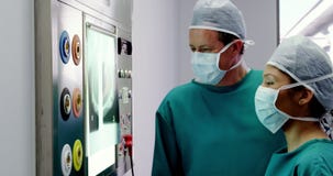 Arts en verpleegster die röntgenstraal bekijken stock videobeelden Arts en verpleegster die röntgenstraal bekijken stock videobeelden