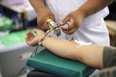Arts tijdens de eenheid van de transfusiebloeddonatie van donor stock fotografie Arts tijdens de eenheid van de transfusiebloeddonatie van donor stock fotografie