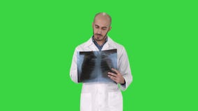 Artsenradioloog die x-ray aftasten bekijken die op het Groen Scherm, Chromasleutel lopen stock footage Artsenradioloog die x-ray aftasten bekijken die op het Groen Scherm, Chromasleutel lopen stock footage