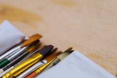 Artystyczni barwioni farb muśnięcia w górę rysunku kłamają na drewnianej palecie obrazy stock Artystyczni barwioni farb muśnięcia w górę rysunku kłamają na drewnianej palecie obrazy stock