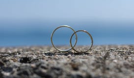 As alianças de casamento colocaram em uma rocha imagem de stock As alianças de casamento colocaram em uma rocha imagem de stock