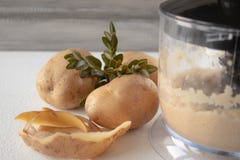 As batatas descascadas misturaram em um misturador em um fundo branco fotografia de stock royalty free As batatas descascadas misturaram em um misturador em um fundo branco fotografia de stock royalty free