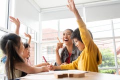 As crianças asiáticas felizes levantarem suas mãos quando chá fêmea imagem de stock As crianças asiáticas felizes levantarem suas mãos quando chá fêmea imagem de stock