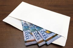As cédulas do dinheiro de Kazkh em um envelope branco encontram-se na tabela Trinta mil tenges são preparados para um presente ou imagens de stock As cédulas do dinheiro de Kazkh em um envelope branco encontram-se na tabela Trinta mil tenges são preparados para um presente ou imagens de stock