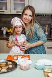 As meninas da cozinha da criança cozinham a colher engraçada pequena da mamã da mãe da decoração do creme do creme do tampão de t foto de stock As meninas da cozinha da criança cozinham a colher engraçada pequena da mamã da mãe da decoração do creme do creme do tampão de t foto de stock