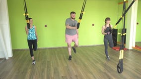 As meninas e os homens das classes do grupo com um instrutor são contratados nos laços de TRX, na perda de peso e no desenvolvime vídeos de arquivo As meninas e os homens das classes do grupo com um instrutor são contratados nos laços de TRX, na perda de peso e no desenvolvime vídeos de arquivo