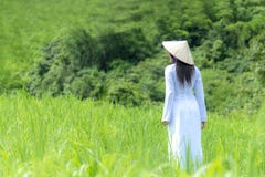 As mulheres asiáticas com o vestido tradicional de Ao-Dai Vietname trajam o passeio da mulher imagens de stock royalty free As mulheres asiáticas com o vestido tradicional de Ao-Dai Vietname trajam o passeio da mulher imagens de stock royalty free