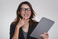 As mulheres asiáticas olham seu iPad com um humor feliz imagens de stock royalty free As mulheres asiáticas olham seu iPad com um humor feliz imagens de stock royalty free
