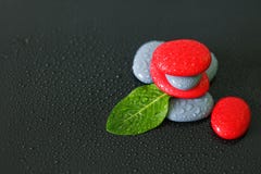 As pedras cinzentas e vermelhas com gotas da água e de uma folha verde arranjaram no estilo de vida do zen no fundo fotos de stock royalty free As pedras cinzentas e vermelhas com gotas da água e de uma folha verde arranjaram no estilo de vida do zen no fundo fotos de stock royalty free