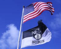 As redes de Brooklyn e as bandeiras americanas que voam na frente de Barclays centram-se fotografia de stock As redes de Brooklyn e as bandeiras americanas que voam na frente de Barclays centram-se fotografia de stock