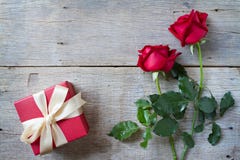 As rosas vermelhas com caixa de presente vermelha woonden sobre o fundo O dia de Valentim, o fundo do aniversário etc. fotos de stock As rosas vermelhas com caixa de presente vermelha woonden sobre o fundo O dia de Valentim, o fundo do aniversário etc. fotos de stock