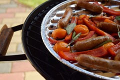 Asado a la parilla de las salchichas y verduras y especias en la parrilla Foto de archivo libre de regalías Asado a la parilla de las salchichas y verduras y especias en la parrilla Foto de archivo libre de regalías
