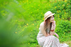 Asian beautiful young girl,wear floral maxi dress. And hat, sitting on the ground at spring Stock Photos Asian beautiful young girl,wear floral maxi dress. And hat, sitting on the ground at spring Stock Photos