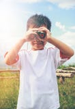 Asian boy looking through a telescope. Child relaxing holiday. V Royalty Free Stock Photos Asian boy looking through a telescope. Child relaxing holiday. V Royalty Free Stock Photos