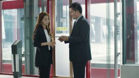 Asian business people talking in elevator hall
