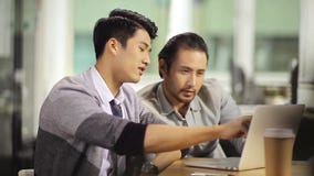 Asian business people working together using laptop