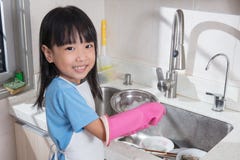 Asian Chinese little girl washing dishes in the kitchen royalty free stock images Asian Chinese little girl washing dishes in the kitchen royalty free stock images