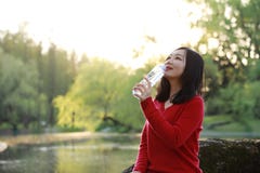 Asian Chinese Pretty Woman Smiling And Drinking Water In Nature In Spring Outdoor Stock Photo