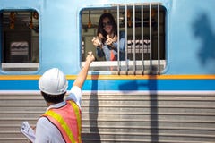 Asian engineer wearing safety helmet show mini heart to girlfriend in train stock image Asian engineer wearing safety helmet show mini heart to girlfriend in train stock image