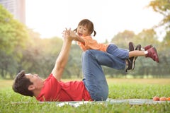 Asian father and his daughter playing together. stock photo Asian father and his daughter playing together. stock photo