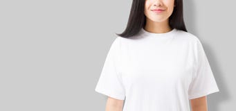 Asian girl in blank template t shirt on gray background. Young woman in tshirt copy space and mock up for advertising. stock image Asian girl in blank template t shirt on gray background. Young woman in tshirt copy space and mock up for advertising. stock image