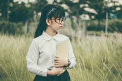 Asian girl outdoors holding folder Asian girl outdoors holding folder