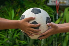 Kid`s hands holding old football royalty free stock photo Kid`s hands holding old football royalty free stock photo