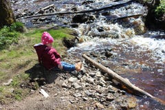 Little girl sitting near a mountain river. royalty free stock photo Little girl sitting near a mountain river. royalty free stock photo