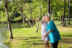 Asian little girl supporting,watching something senior woman with walking stick,happy smiling grandmother,granddaughter in outdoor royalty free stock photography Asian little girl supporting,watching something senior woman with walking stick,happy smiling grandmother,granddaughter in outdoor royalty free stock photography