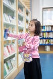 The lovely little girl reads in the library stock photography The lovely little girl reads in the library stock photography