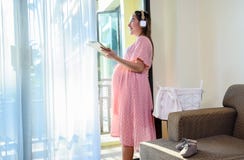Asian Pregnant Woman Stay At Home Alone. Listen To Music Of Pregnancy Royalty Free Stock Photo