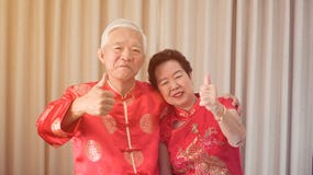 Asian senior couple celebrate Chinese new year in red traditional costume stock images Asian senior couple celebrate Chinese new year in red traditional costume stock images