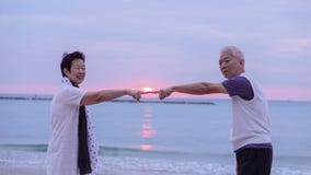 Asian senior couple together at sunrise beach. New year, new cha Stock Photography Asian senior couple together at sunrise beach. New year, new cha Stock Photography