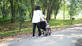 Asian senior or elderly old lady woman patient with care, help and support on wheelchair in park in holiday: healthy strong medica