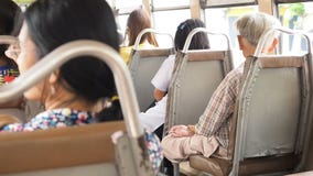 Asian senior man sitting in the lotus position in a motor vehicle seat and thinking about something in tram while sunny stock video Asian senior man sitting in the lotus position in a motor vehicle seat and thinking about something in tram while sunny stock video