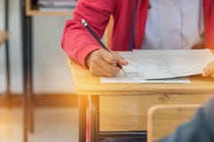 Asian Students holding pencil in hand doing multiple-choice quiz royalty free stock photography Asian Students holding pencil in hand doing multiple-choice quiz royalty free stock photography