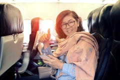 Asian woman on economy class seat of domestic airline plane sign Royalty Free Stock Photos Asian woman on economy class seat of domestic airline plane sign Royalty Free Stock Photos
