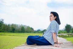 Asian woman sitting cross leg on bamboo bridge at rice field at. Evening time feel relax and fresh with clam emotion.natural travel Stock Photography Asian woman sitting cross leg on bamboo bridge at rice field at. Evening time feel relax and fresh with clam emotion.natural travel Stock Photography