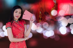 Asian woman wearing red traditional dress holding red pocket with the chinese new year festival background with lanterns stock image Asian woman wearing red traditional dress holding red pocket with the chinese new year festival background with lanterns stock image