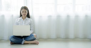 Asian Women Who Are Using A Laptop In A Warm House Stock Photography