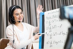 Asian young school woman teacher working from home teach online math subject to student studying from home. Girl points on whitebo