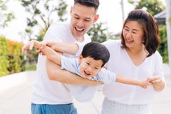 Asiatische Familie, die Spaß hat und öffentlich einen Kinderpark trägt lizenzfreies stockfoto Asiatische Familie, die Spaß hat und öffentlich einen Kinderpark trägt lizenzfreies stockfoto