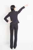 Asiatische Geschäftsfrau der hinteren Ansicht, die weg zeigt lizenzfreies stockfoto Asiatische Geschäftsfrau der hinteren Ansicht, die weg zeigt lizenzfreies stockfoto