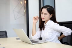 Asiatische Geschäftsfrauen mit Rückenschmerzensünde ein Büro und Arbeitsha stockbild Asiatische Geschäftsfrauen mit Rückenschmerzensünde ein Büro und Arbeitsha stockbild